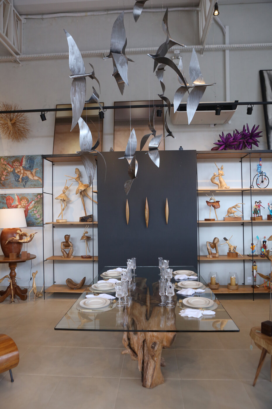 : A mesa de vidro com pé de raiz de abacateiro é o destaque do ambiente (Foto: Notre Design/Divulgação) 