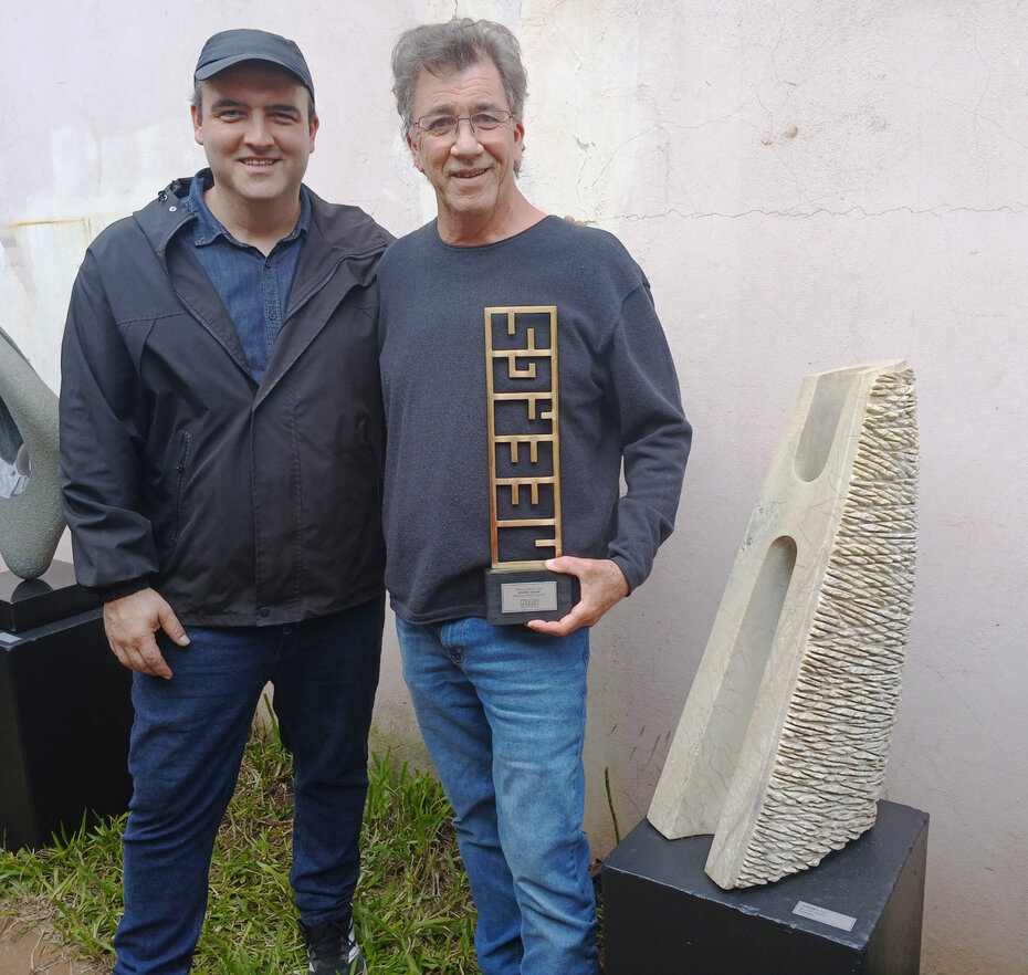 Vinicius Vieira, presidente da AEERGS, com o escultor premiado Ricardo Aguiar, ao lado de uma obra sua (Foto: Carlos Souza/Divulgação)