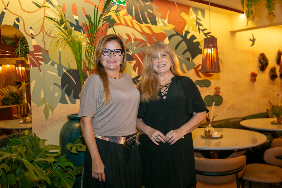 Amanda de Oliveira e Nelci Guadagnin tendo ao fundo o colorido painel do est&uacute;dio Voz &ndash; Arte & Design (Foto: Lenara Petenuzzo/Divulga&ccedil;&atilde;o)