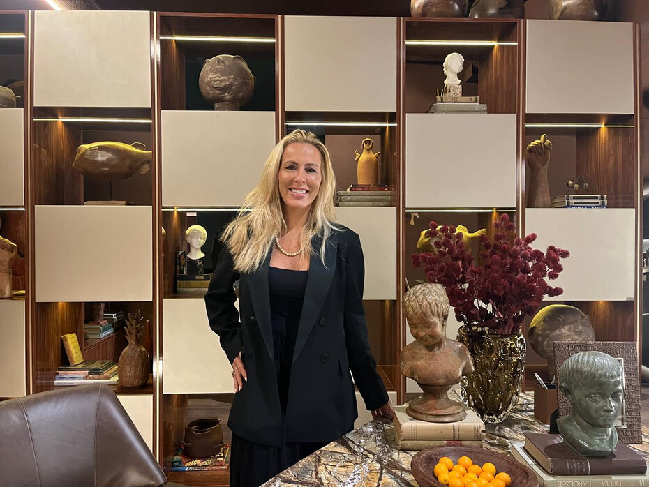 Liana de Lamare tendo ao fundo estante decorada com peças selecionadas na Divina Brasilidade (Foto: Divulgação)