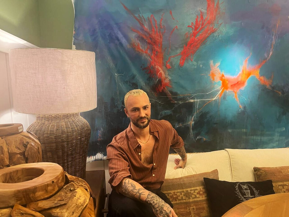 Renam Canzi tendo ao fundo sua obra (Foto: Divulgação)